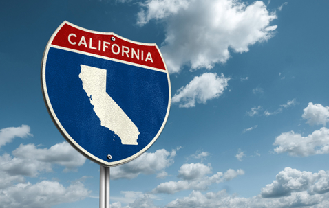 California interstate highway sign with the state outline against a blue sky. | The Law Offices of Andrea Schneider