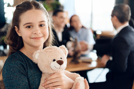 girl with parents stands in the office of a lawyer