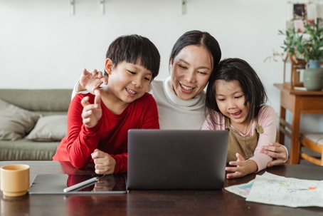 mother and children on laptop sitting together