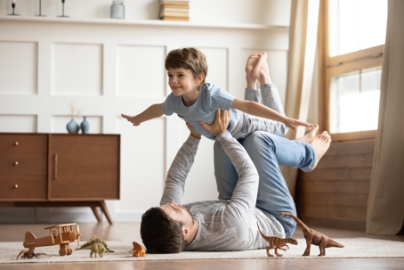 Father and son playing in the living room | The Law Offices of Andrea Schneider